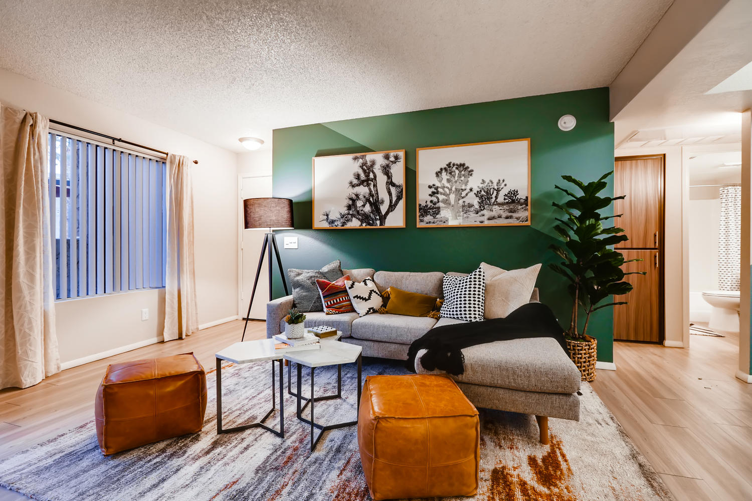 living room area with couch and green accent wall with a large window