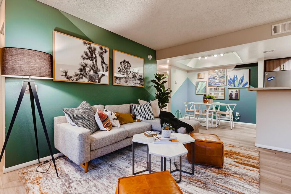 living room space with grey couch and floor lamp, with slight view of dining area