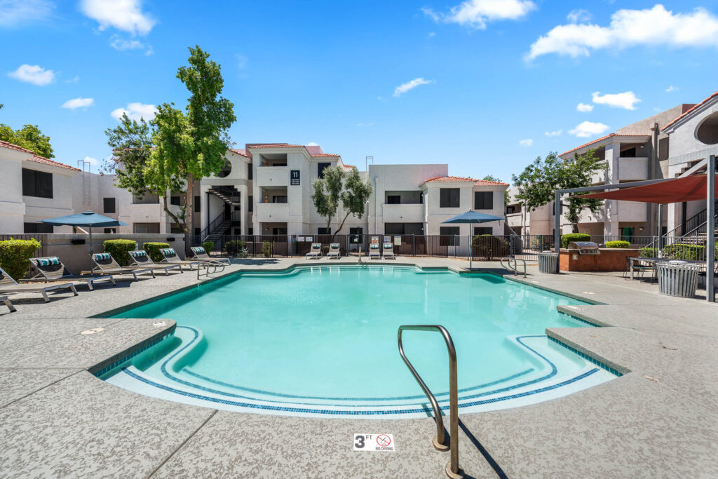swimming pool with patio space and lounge seating with covered grill section