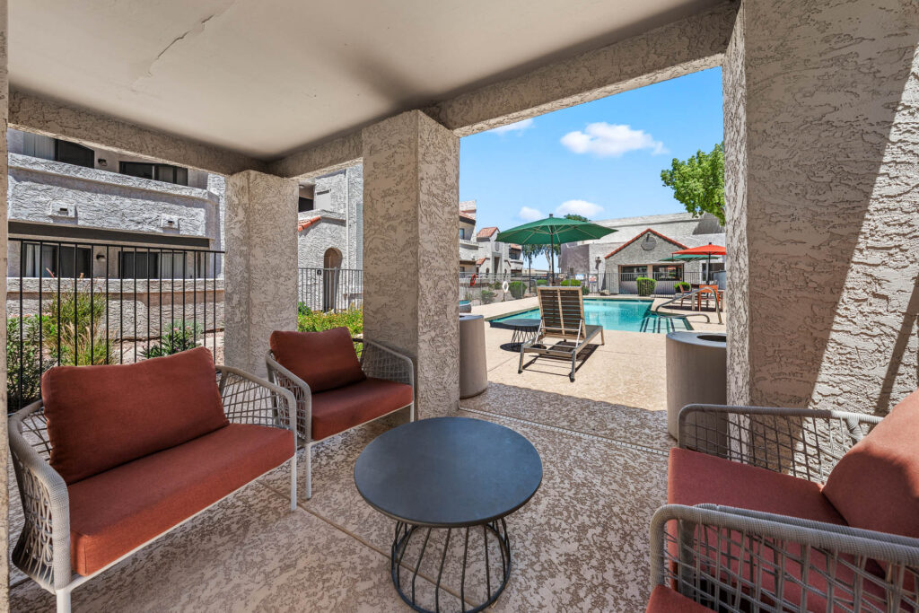 covered outdoor lounge seating adjacent to outdoor swimming pool