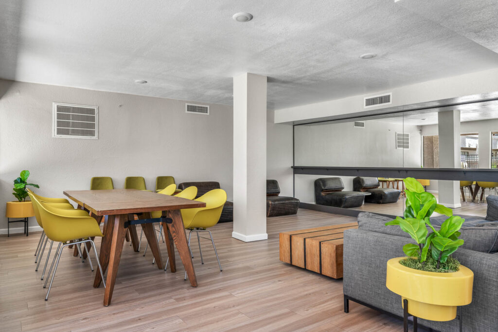 indoor lounge space with various armchair and sofa seating, including a dining table with chairs and a large wall mirror