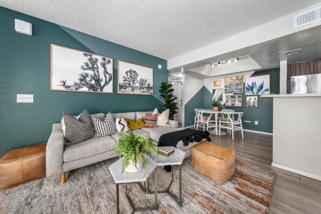 living room and dining space with accent wall, wall decor, sofa and coffee table and dining table and chairs