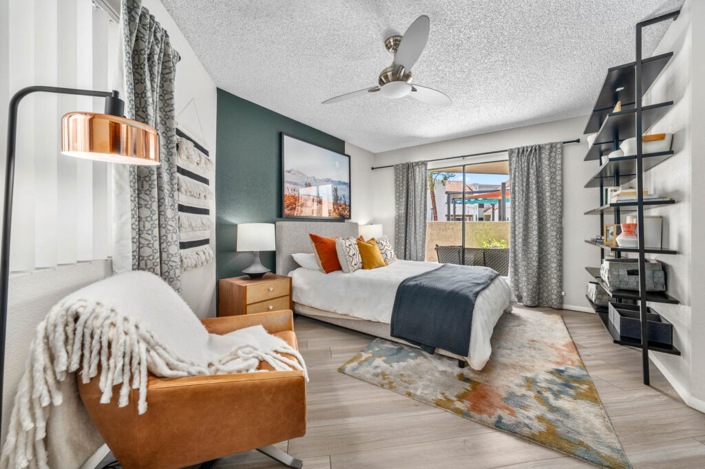 Bedroom with wood-style flooring, lamps, ceiling fan, accent walls, and designer lighting