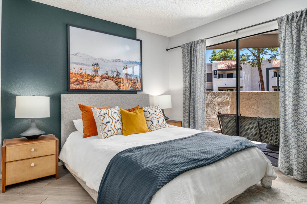 Bedroom with wood-style flooring, lamps, wall decor, accent walls, and designer lighting
