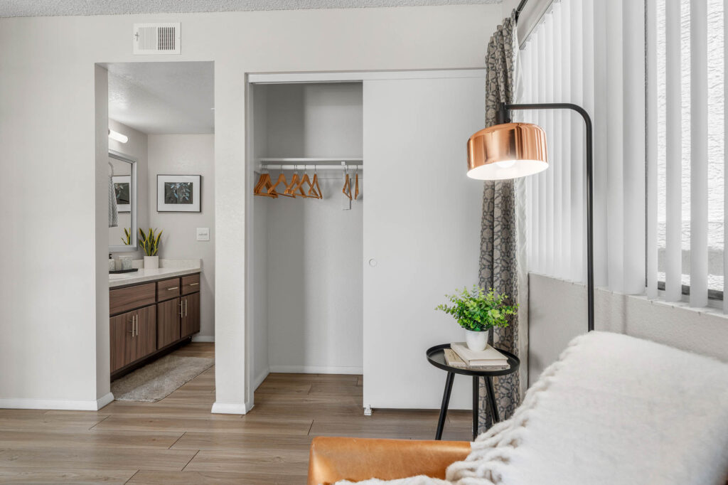 Bedroom with wood-style flooring, large closet, window, and access to bathroom