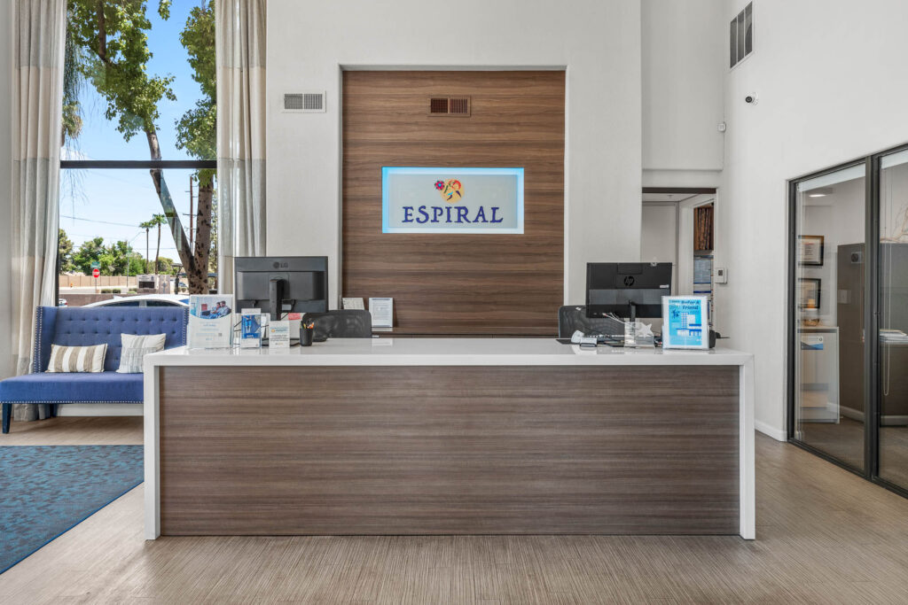 reception area with computers and Espiral Apartments signage in lobby area