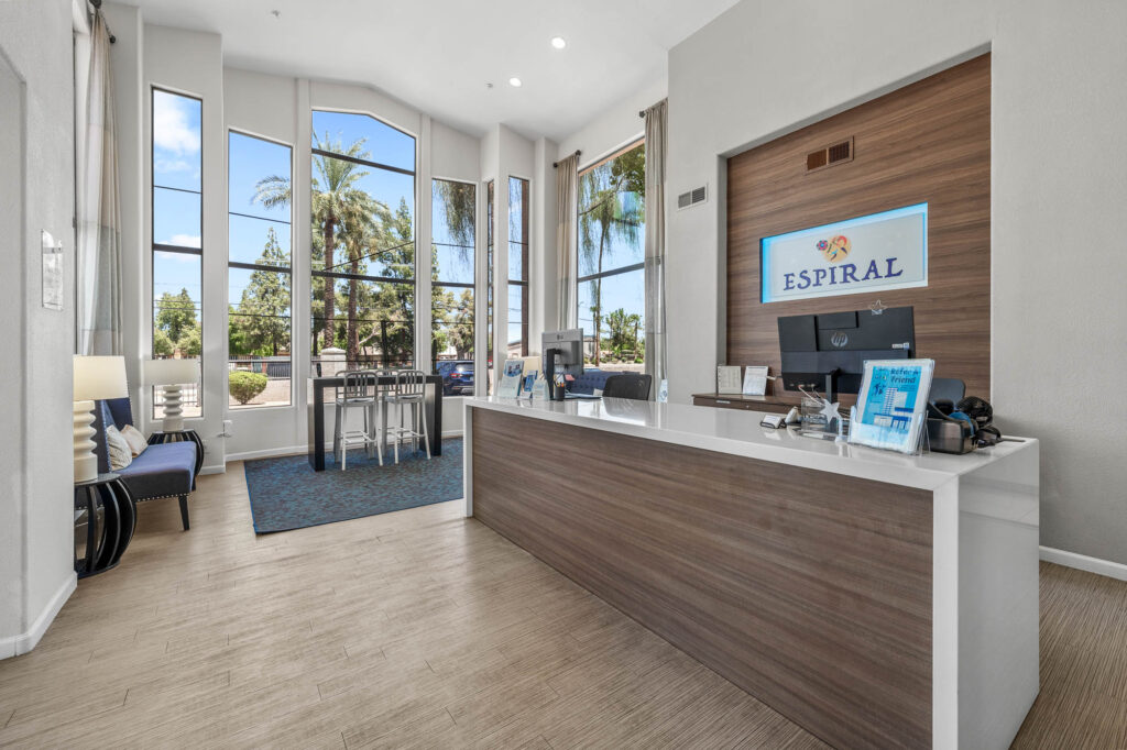 reception area with computers and Espiral Apartments signage in lobby area