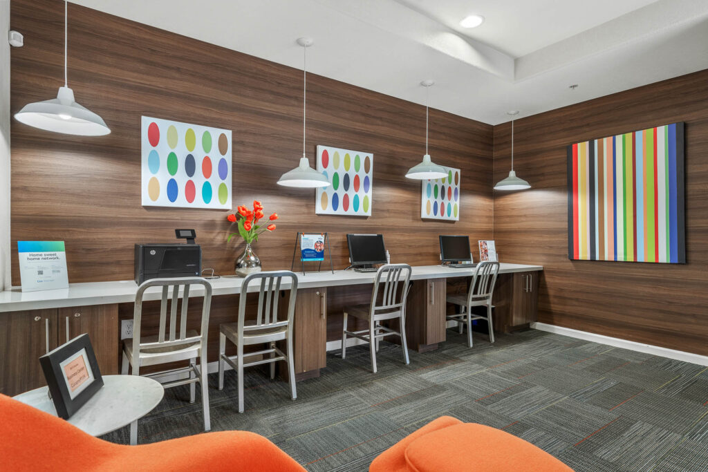Computer room with carpet flooring, designer lighting, computers, and wall decor