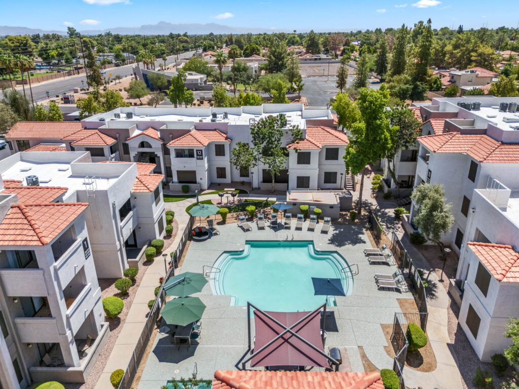 Aerial view of swimming pool, outdoor deck, and apartment complex